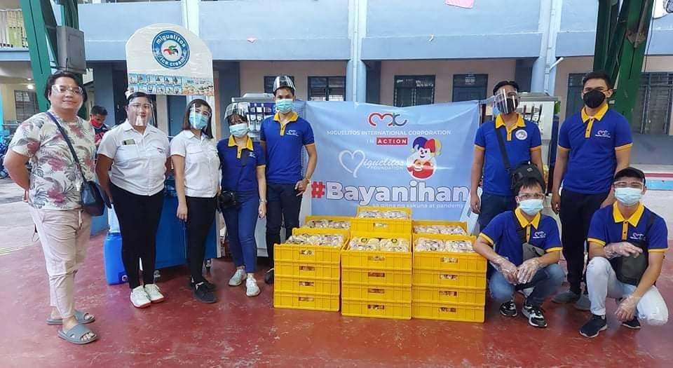 Volunteers and partners posing with a Bayanihan banner