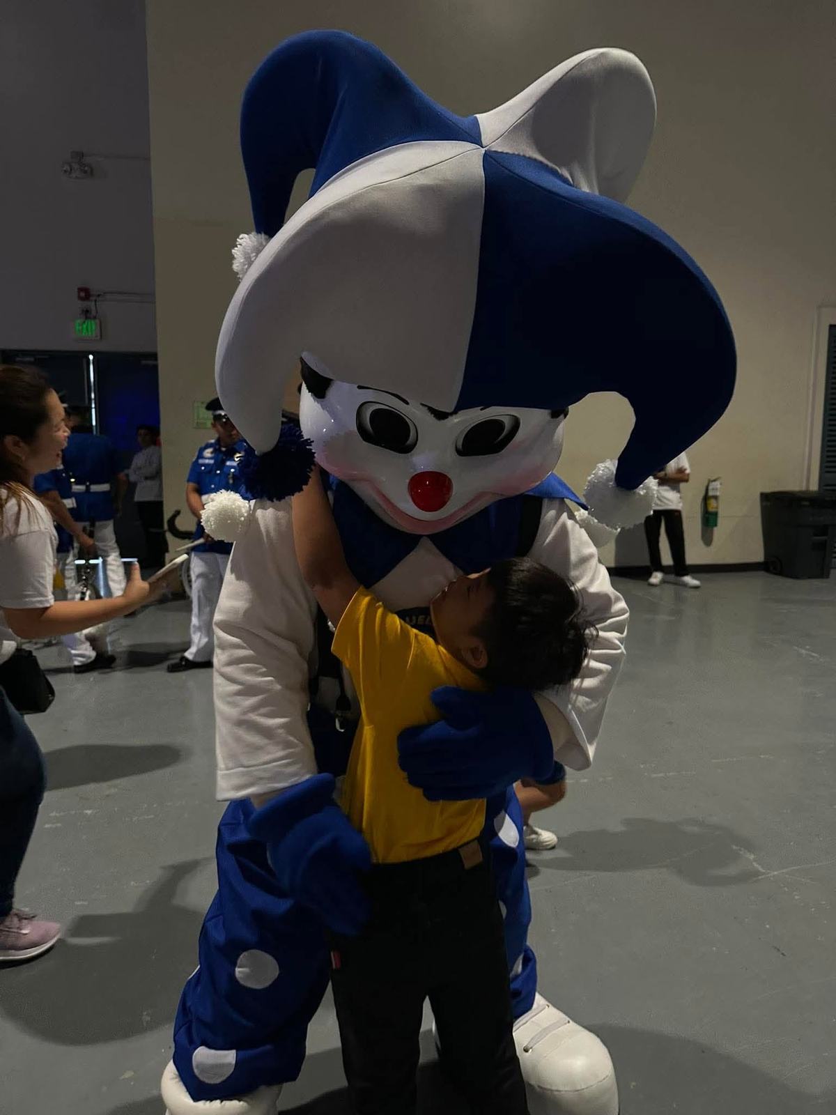 A child hugging the Miguelitos mascot
