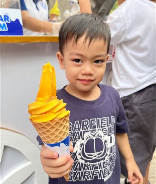 A young boy holding a Miguelitos ice cream cone