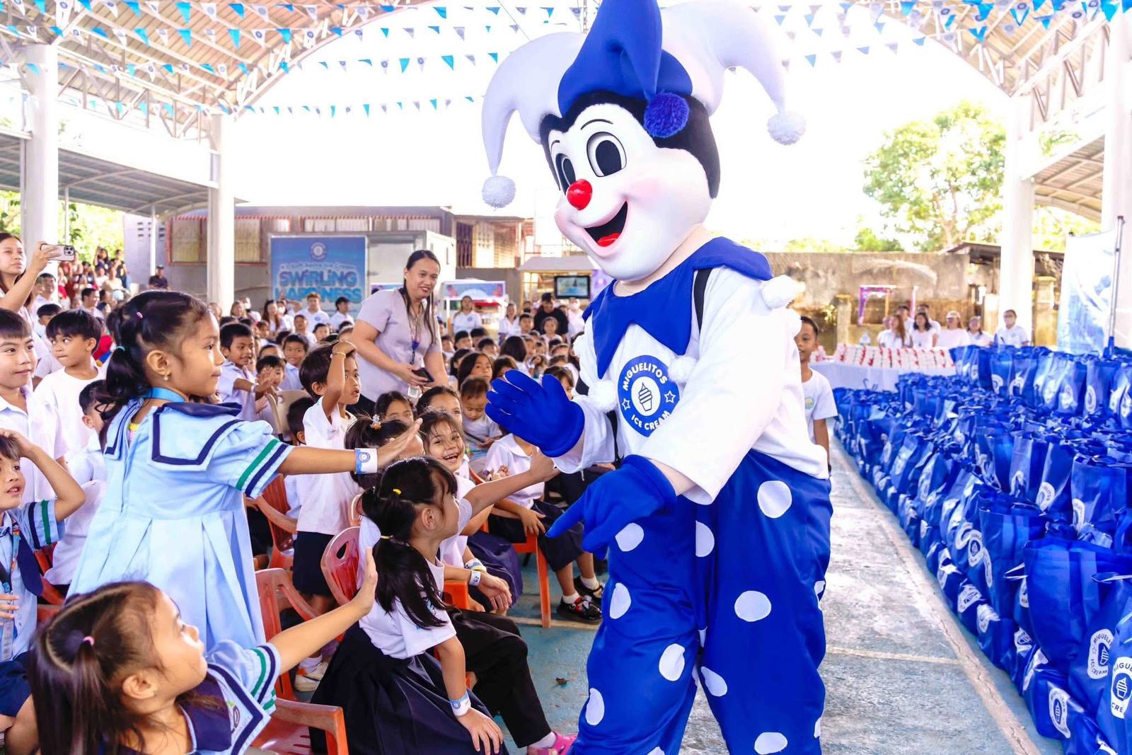 Miguelitos mascot greeting schoolchildren