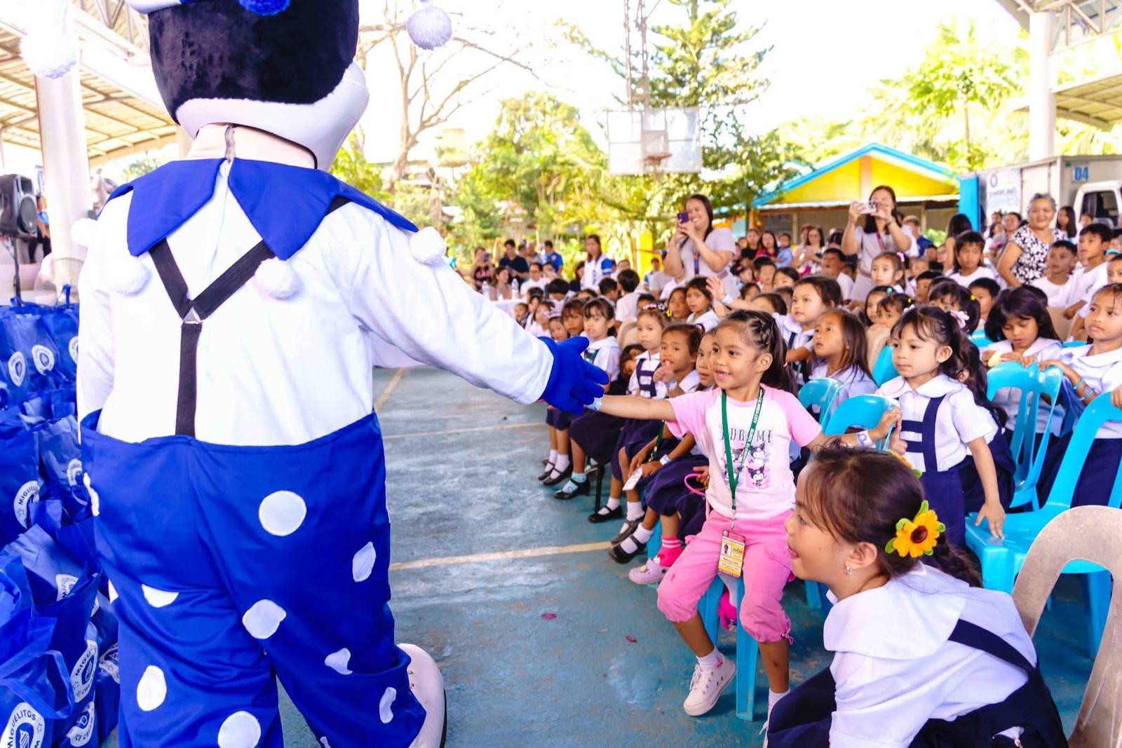 Volunteers in Miguelitos shirts with children