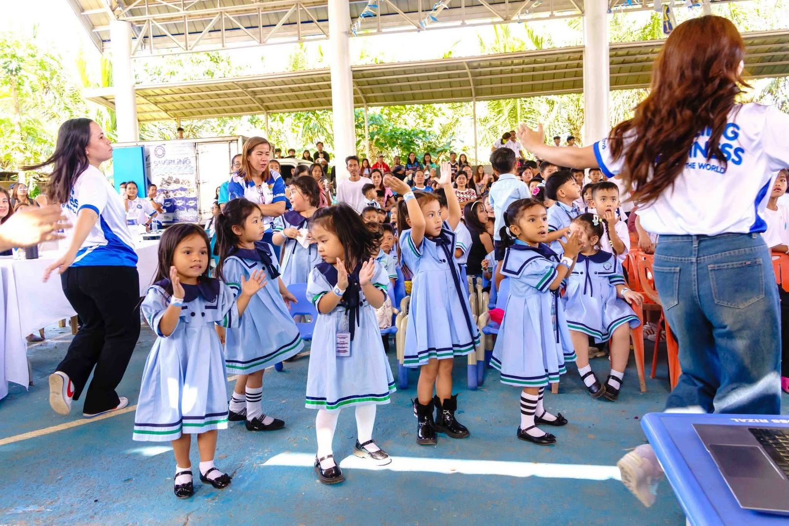 Children dancing with a volunteer